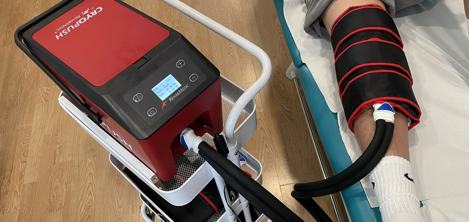 Manga de crioterapia con compresión colocada en la rodilla junto al equipo Cryopush