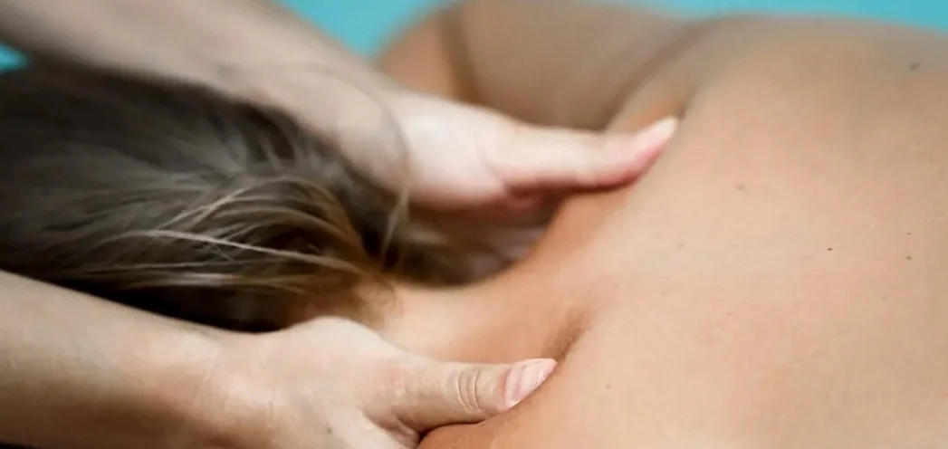 Fisioterapeuta aplicando terapia manual en la zona cervical de una paciente